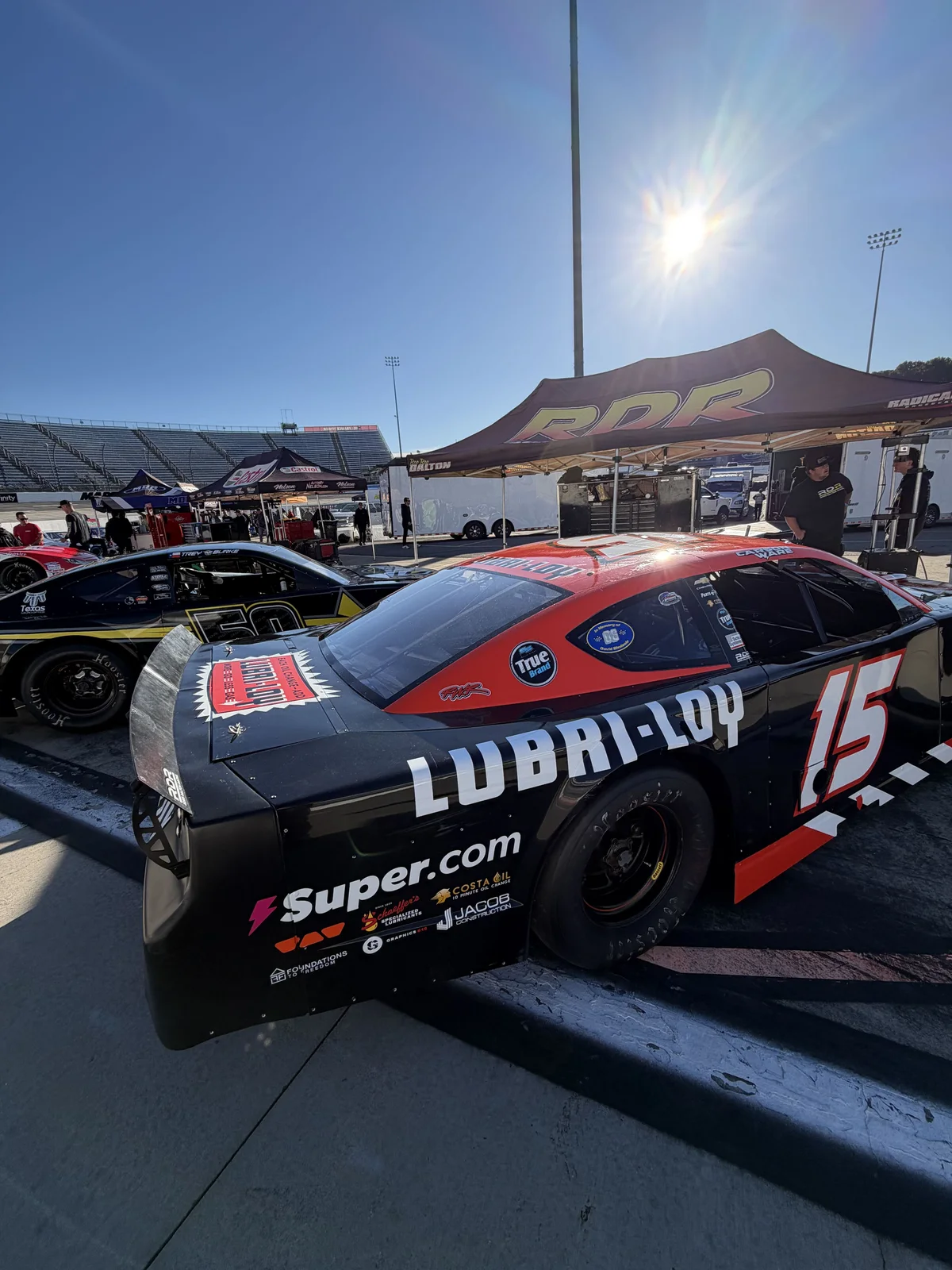 Lubri-Loy-branded No. 15 race car in the paddock